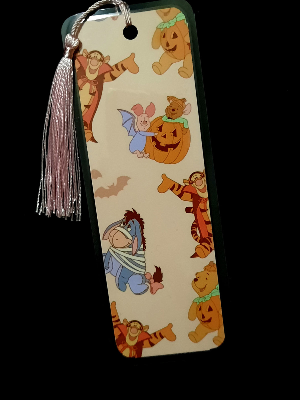 Laminated 2x6 bookmark with tassel, featuring Winnie the Pooh and friends dressed up in Halloween costumes. 