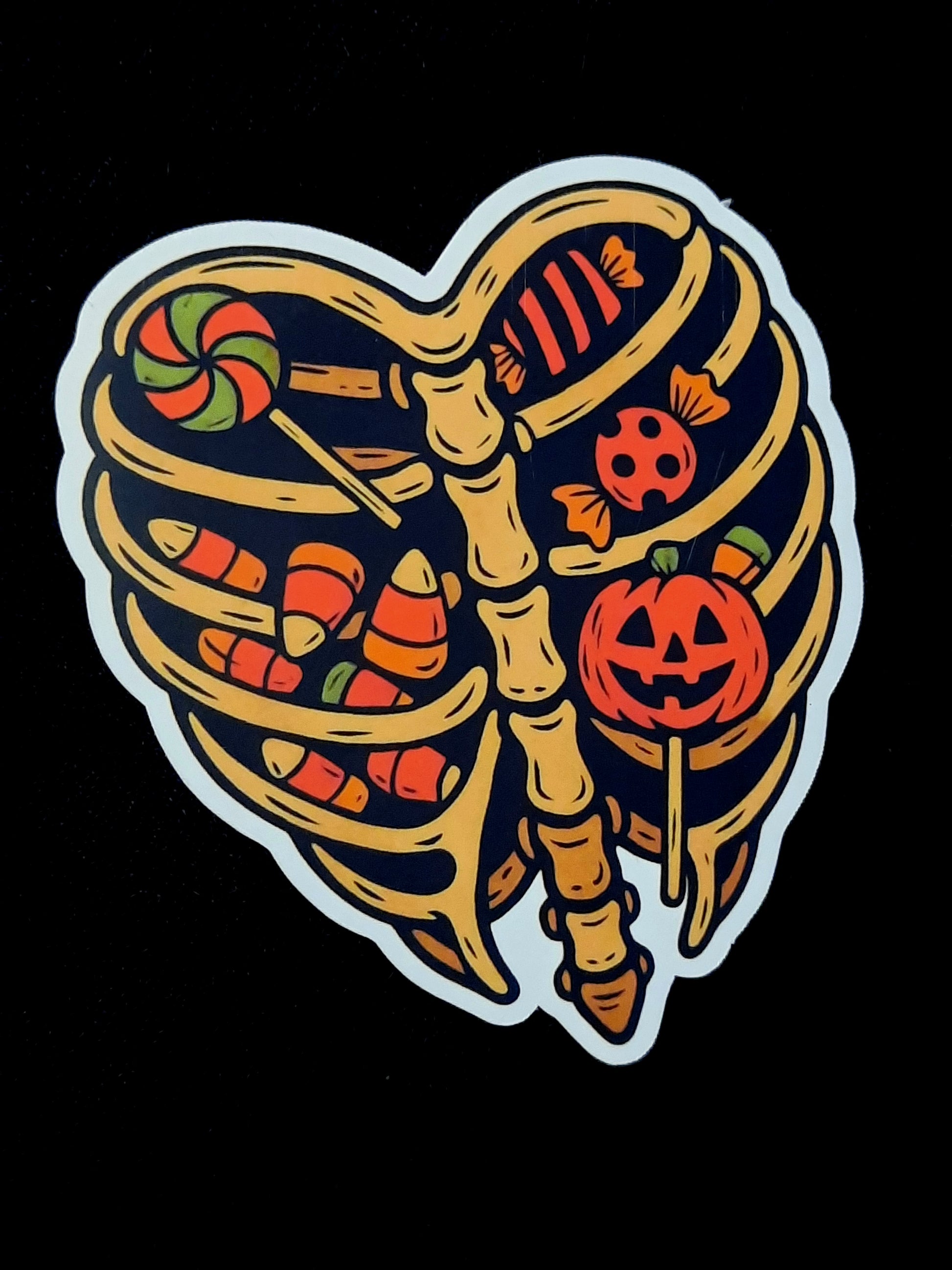 Decorative sticker with skeleton ribcage design featuring Halloween elements on a black background